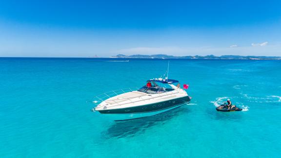 Fancy It is anchored off Ibiza while a person rides a jet ski nearby.