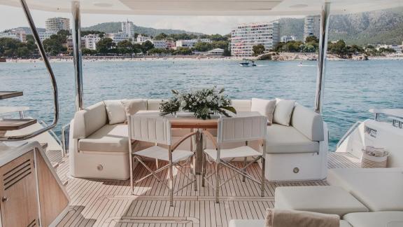 The aft deck of Lady M in Mallorca features a floral table and cushioned seating.