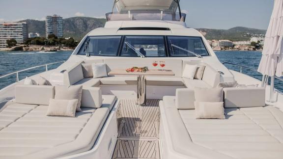 The bow of Lady M in Mallorca includes sunbeds and a table set with drinks.
