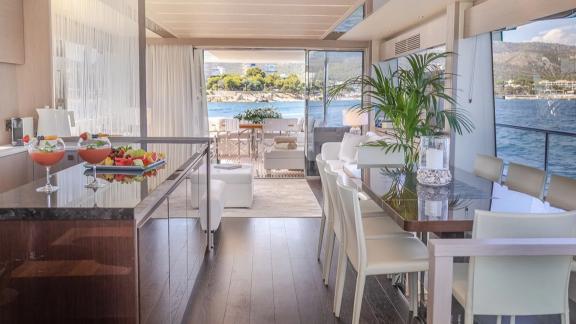 The main salon of Lady M in Mallorca includes a dining table, bar counter and sea view.