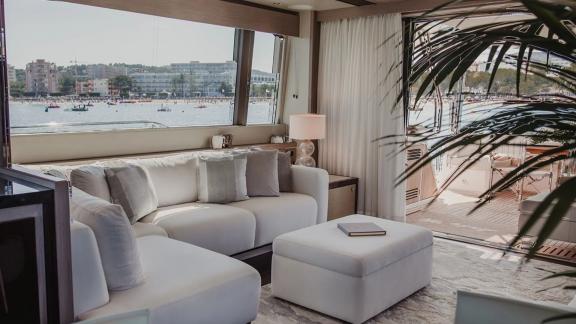 The salon of Lady M in Mallorca includes large windows, corner sofa and ottoman.