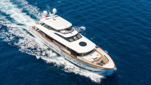 Die geräumige Motoryacht Rem fährt durch blaues Wasser und ist zur Miete verfügbar.