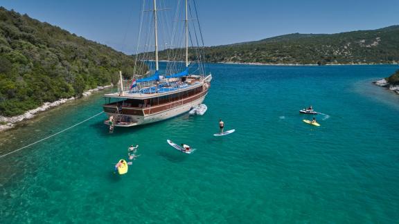 Gulet aus Split, vor Anker in einer Bucht mit Menschen, die Wassersport treiben.