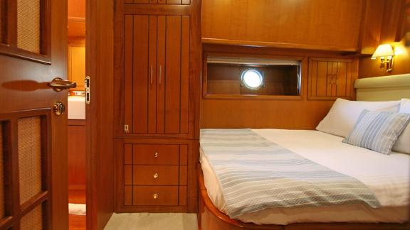 In Bodrum gulet charter option Tango Charlie cabin with bed storage cabinets and bathroom entrance visible.