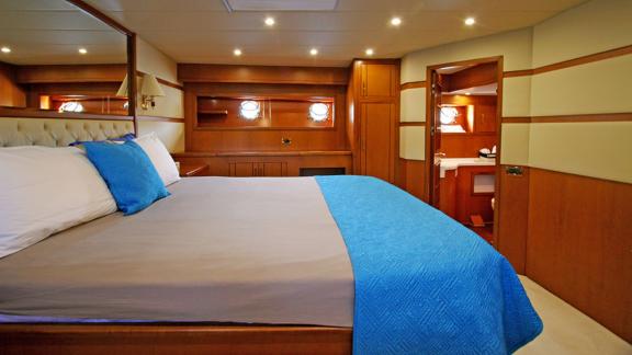 In Bodrum gulet charter option Tango Charlie master cabin with large bed and bathroom entrance visible.