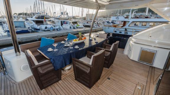 Eleganter Essbereich auf der Motoryacht mit Blick auf den belebten Yachthafen.