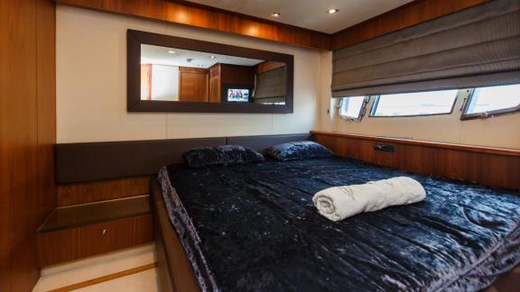 Komfortables Schlafzimmer mit stilvoller Ausstattung und Fensterblick auf einer Motoryacht.