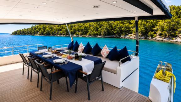 On the flybridge of Beluga 1 in Göcek, an open air dining area overlooks the scenic coastline.