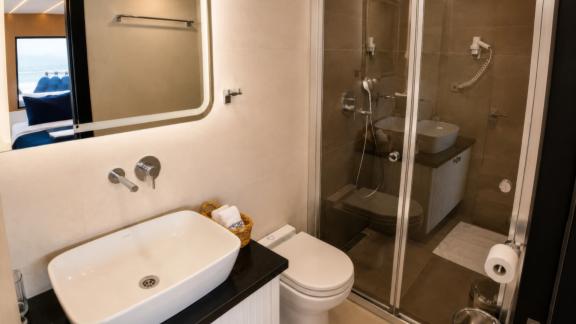 The private bathroom of Beluga 1 in Göcek features a glass shower cabin and a modern sink unit.