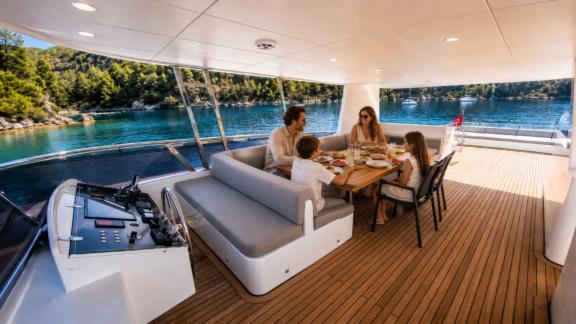 Guests enjoy dining together on the flybridge of Beluga 1 while cruising the bays of Göcek.