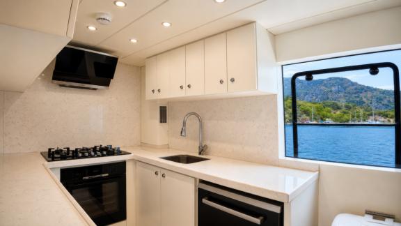 The modern galley of Beluga 1 in Göcek features a stove, oven and a sea view preparation area.