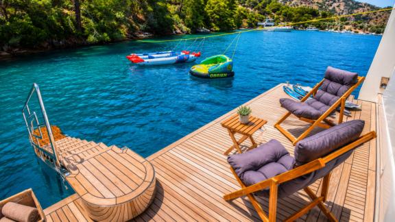 Beluga 1 in Göcek features a swim platform lounge area and water sports equipment by the sea.