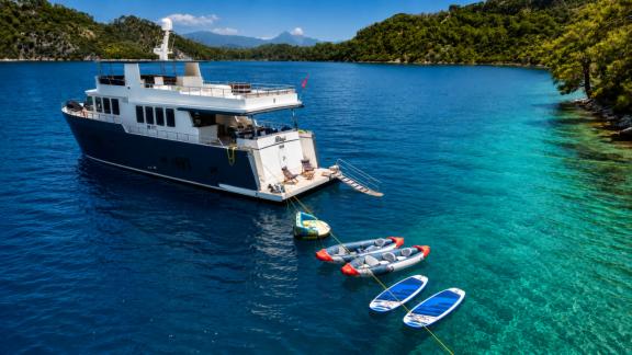 Anchored in Göcek, Beluga 1 features paddle boards and tenders for a blue cruise holiday experience.