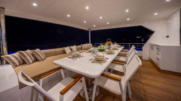 Elegant dinner setup on Lila trawler’s outdoor deck near Fethiye at night.