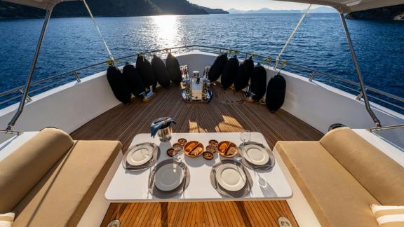 Four-person table and comfortable seating on bow deck of Lila trawler yacht in Fethiye.