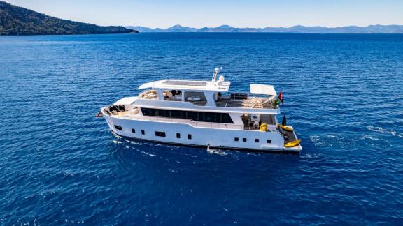 Lila trawler yacht moves slowly and comfortably on calm waters off Fethiye, Turkey.