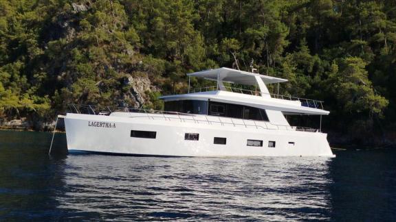 Die modern gestaltete weiße Trawler-Yacht Lagertha liegt vor Anker in einer der ruhigen Buchten von Göcek.