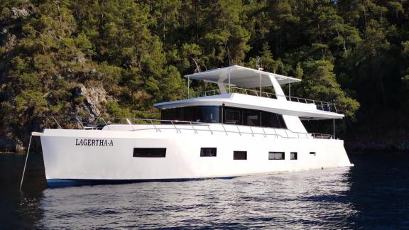 Die weiß lackierte Lagertha Trawler-Yacht liegt friedlich vor Anker in einer der ruhigen Buchten von Göcek.