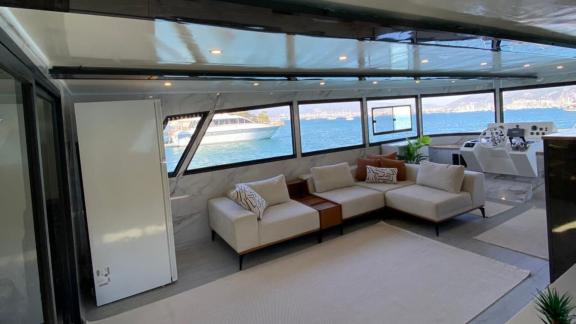 Der geräumige Salon der Trawler-Yacht Lagertha mit Panoramablick bietet ein helles Ambiente auf See.