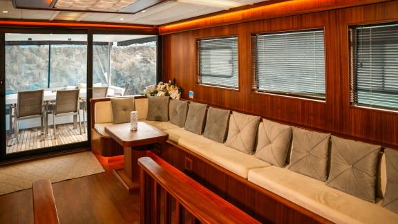 Spacious lounge area with wide windows inside the Oggusto trawler yacht anchored in Fethiye.