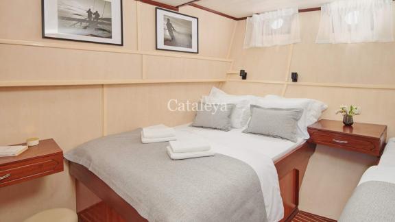 A stylish cabin with a double bed and a single bed on the Gulet Cataleya, ideal for a relaxing cruise in Croatia.