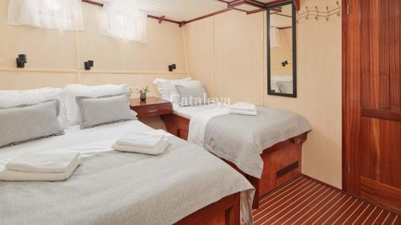 A cosy cabin with a double bed and a single bed, ideal for families, on board the Gulet Cataleya in Croatia.