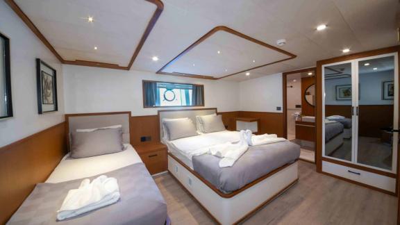 Das komfortable Schlafzimmer der Yacht Çınar Yıldızı mit einem großen Bett und einem zusätzlichen Einzelbett ist ideal f