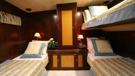 Stylish twin cabin with bunk bed and single bed on a yacht in Bodrum.