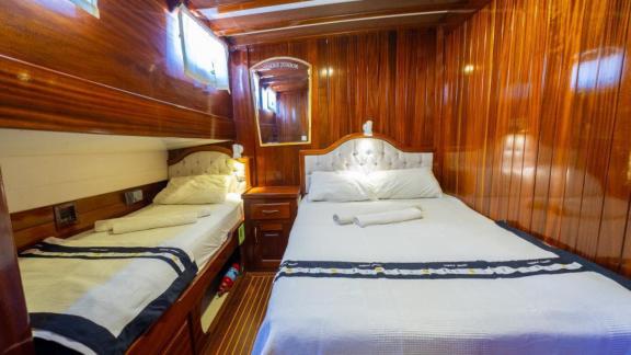 Triple cabin of Gulet Cemre Junior with one double and one single bed.