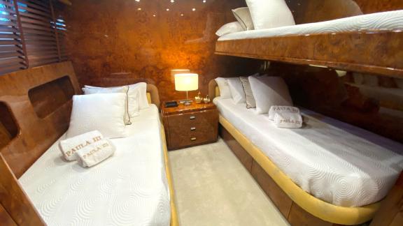 The guest cabin on Paula 3 yacht features a bunk bed and stylish decor.