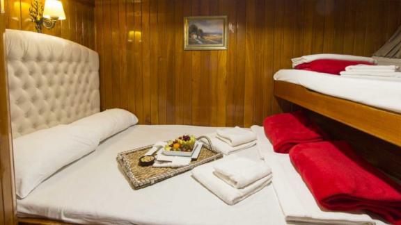 Cabin with double bed and bunk bed, perfect for families on board the Gulet Hera.