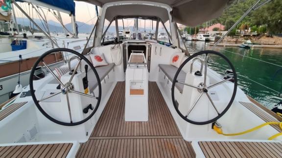 The spacious aft cockpit of Triton 89 sailing yacht features a dual helm system and comfortable seating areas.