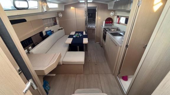 The interior of Triton 89 sailing yacht offers a cozy environment with comfortable seating and a dining table.