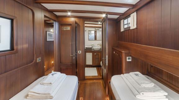 Double cabin of the gulet yacht Jasemin 1 with two single beds and access to the bathroom.