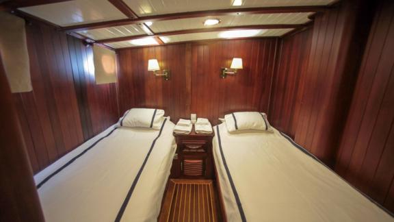 A two-bed cabin on board the Gulet Dulcinea with stylish wood panelling and cosy lighting.