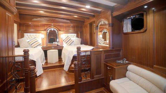 Two single beds, stylish wooden decor, and luxurious decorations in the yacht's bedroom