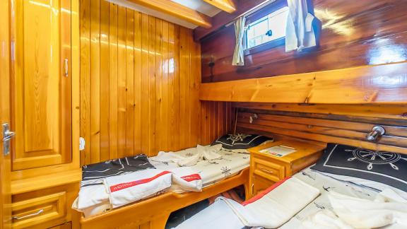 Bright cabin with two single beds and wooden walls. Perfect for comfortable nights at sea.