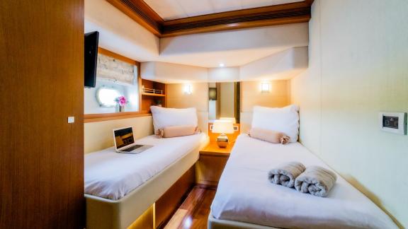 На яхте Ferretti 780 Orlando L светлая гостевая каюта с отдельными кроватями и уютной атмосферой.