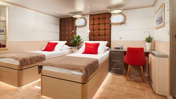 Spacious twin bed cabin with desk on the motor yacht Queen Eleganza