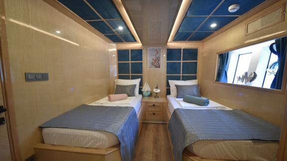 The twin bedroom of the trawler Compass features comfortable beds and stylish design.