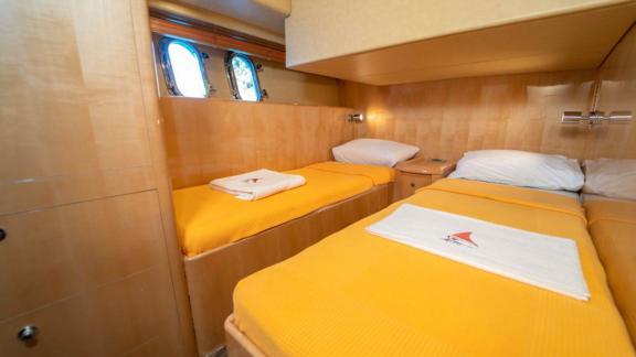 Guest cabin of motor yacht İmera with twin beds and windows.