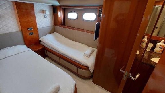 The cabin of the yacht Cielo features a double bed and a single bed, a window, and a bathroom.