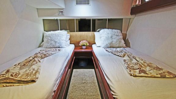 Twin cabin of the motor yacht Queen with comfortable beds and elegant decor.