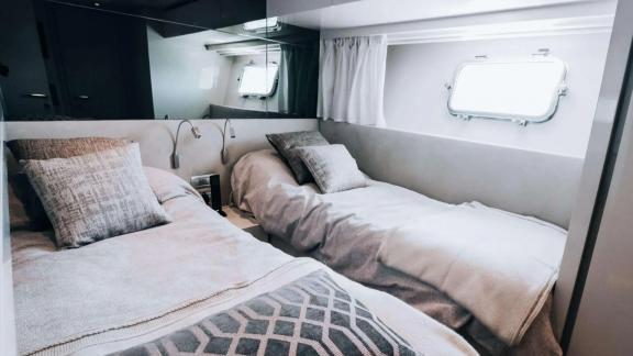 The twin room on motor yacht Coco De Mer provides a cozy stay with elegant pillows and lighting.