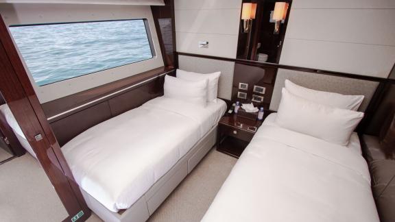 The twin guest bedroom of the Legende motor yacht, featuring sea views, adds comfort to your Dubai yacht rental experien