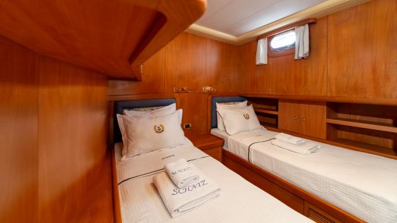 The twin cabin of Mein Schatz features warm wood decor and cozy beds, perfect for a gulet charter in Bodrum.