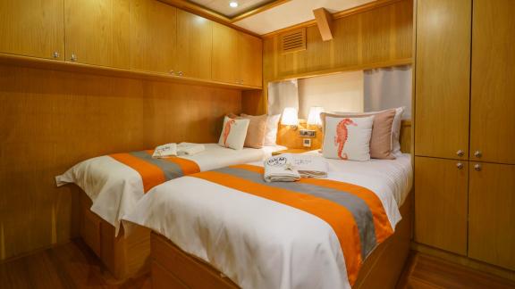 Stylish two-bed cabin on the Gulet Happy Hours with comfortable beds and wood panelling.