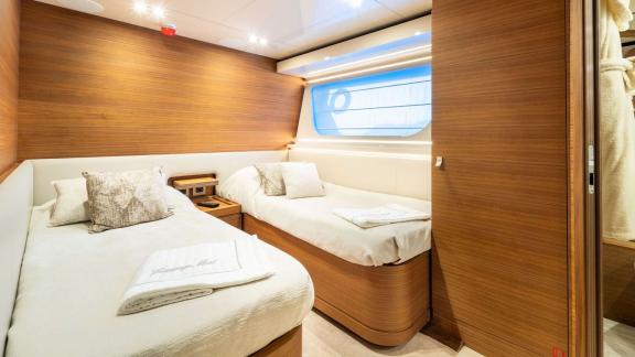 На Ferretti Navetta 28 гостевая каюта оборудована двумя кроватями и окном с видом на море.