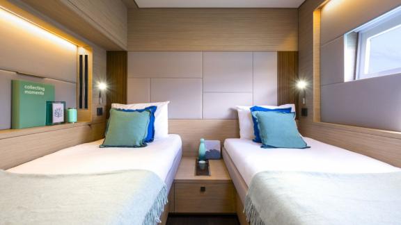 Twin-Kabine auf der Lady M bei Athen mit Fenster zum Meer und schlichter moderner Einrichtung.