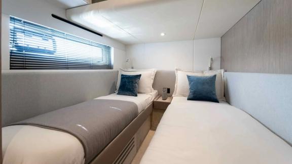 Bright and modern twin bed guest cabin with elegant design and soft lighting.